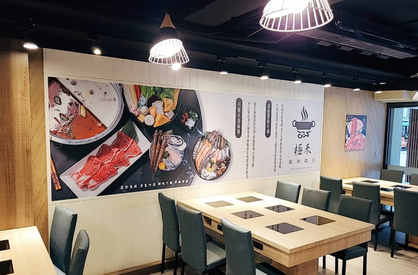大型餐桌、吊燈與鍋物品牌壁面構成的用餐空間