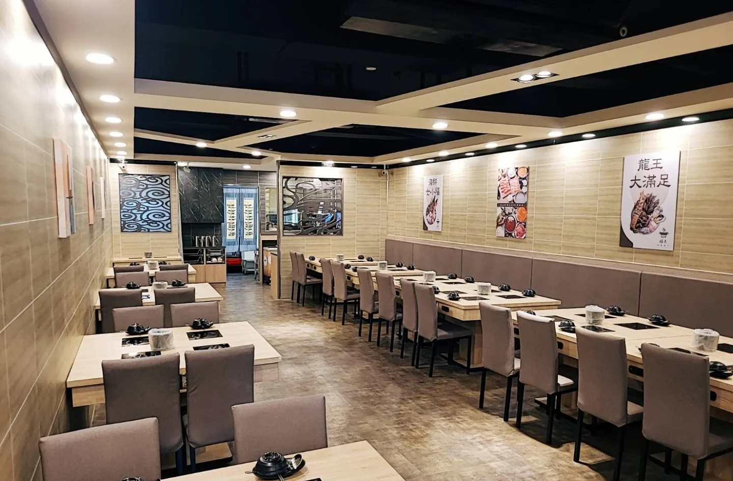 長型鍋物用餐空間裡整齊延伸的桌席與天花燈帶